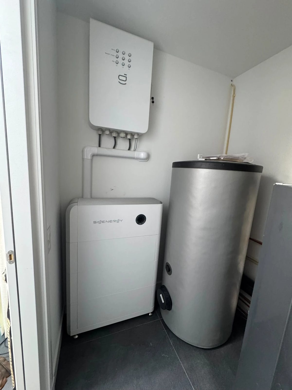 Sigenergy-thuisbatterij en omvormer in een bijkeuken naast de boiler